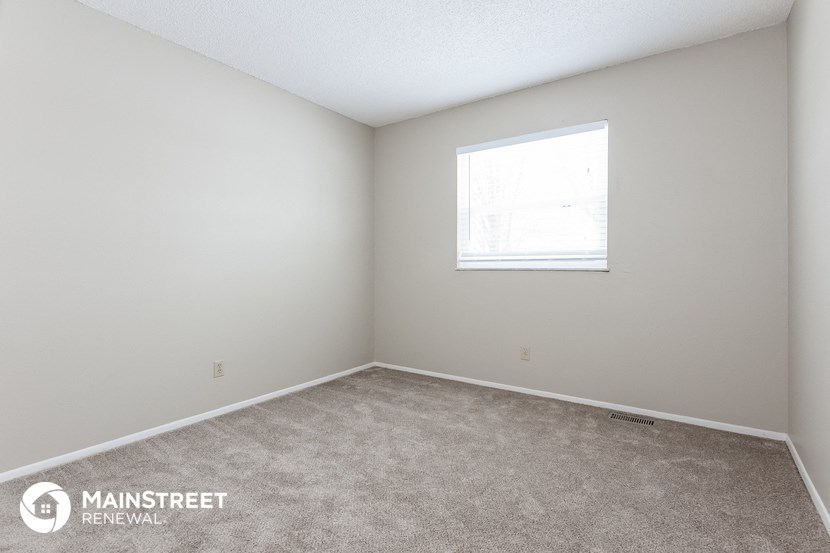 a bedroom with a carpeted floor and a window