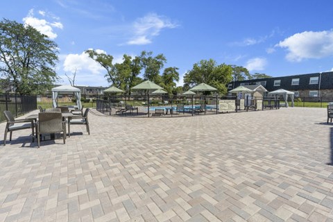 a patio with tables and chairs and umbrellas