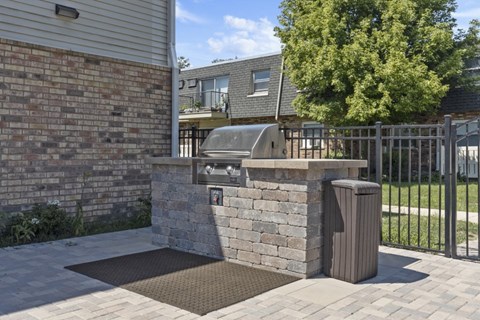 a stone barbecue grill in the backyard of a house
