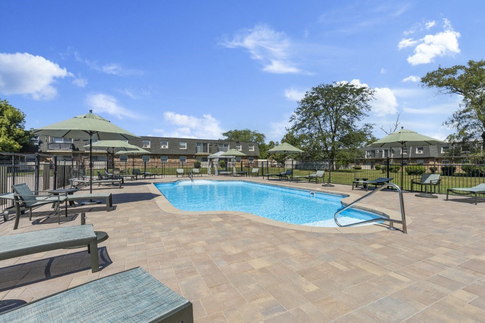 a resort style pool with lounge chairs and umbrellas