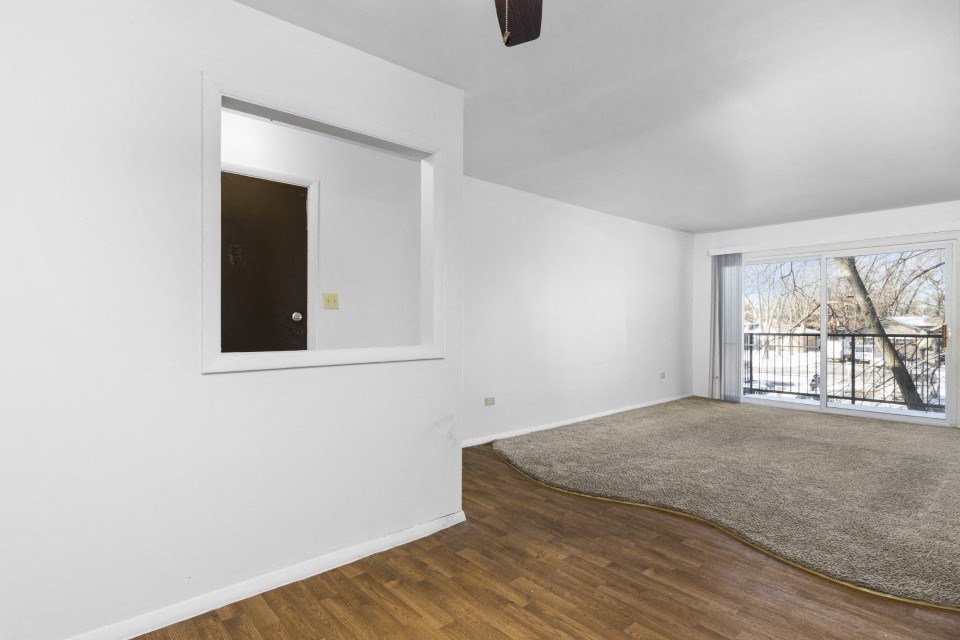 an empty living room with a window and a rug