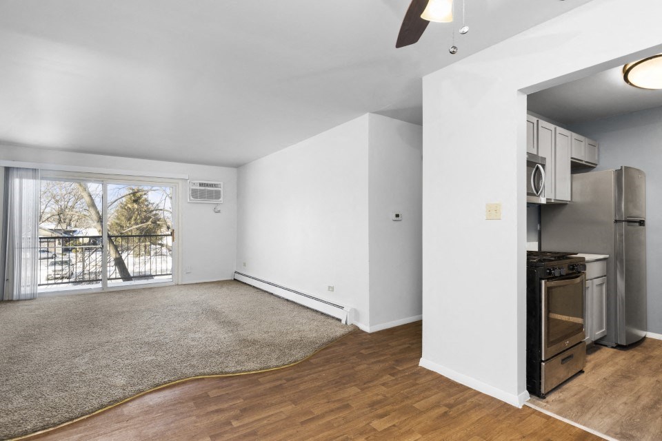 a living room with a kitchen and a sliding glass door