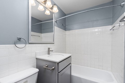 a bathroom with a sink and a tub and a mirror