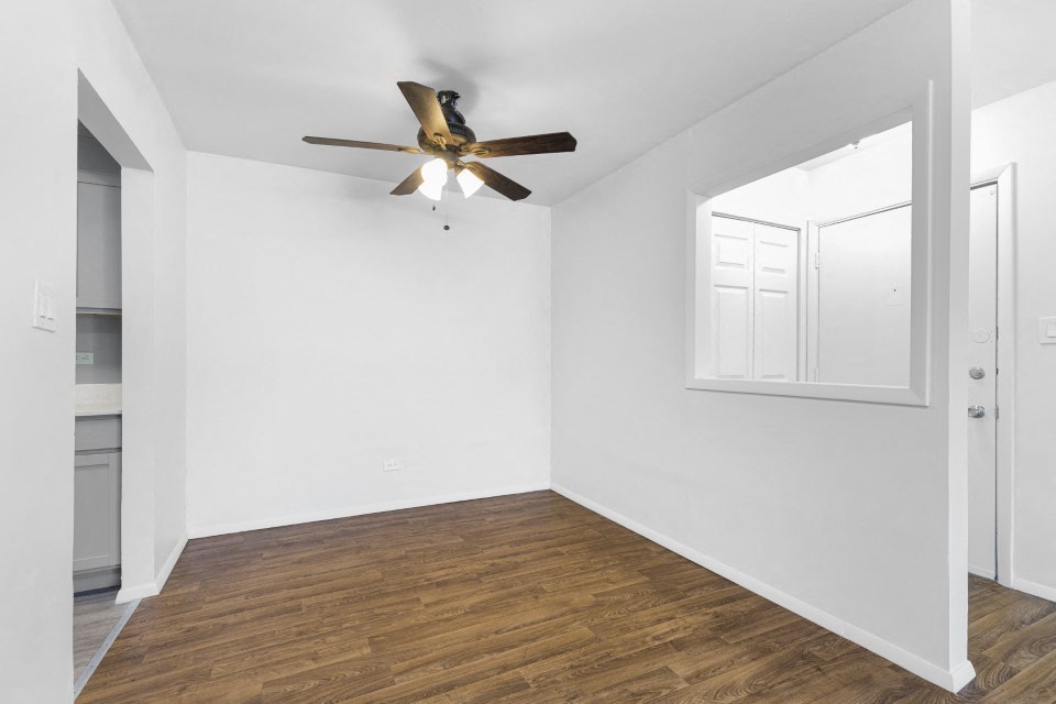 a bedroom with white walls and a ceiling fan