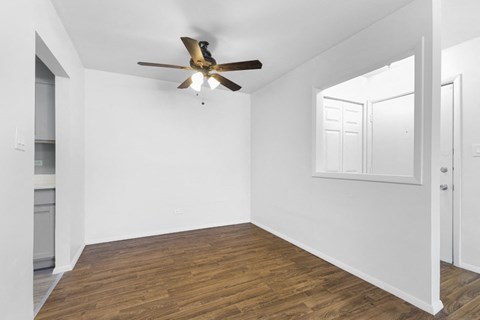 a bedroom with white walls and a ceiling fan