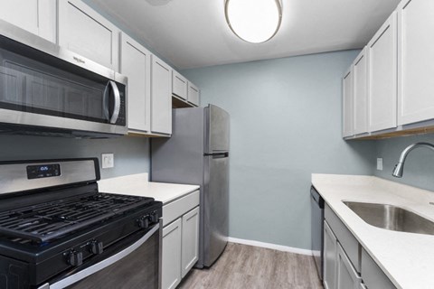 a kitchen with stainless steel appliances and white cabinets
