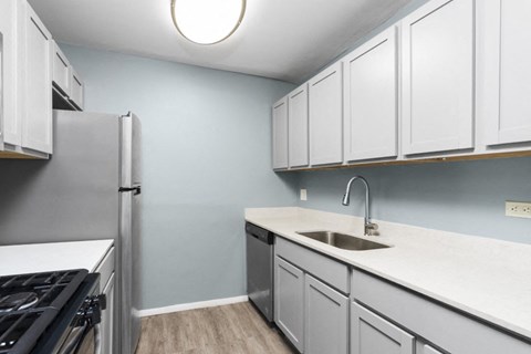 a kitchen with white cabinets and a stainless steel refrigerator