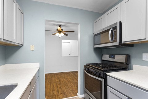 a kitchen with a stove and a microwave and a ceiling fan