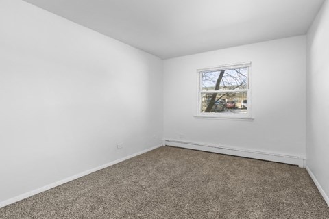 an empty room with white walls and a window