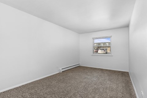 an empty room with white walls and a window