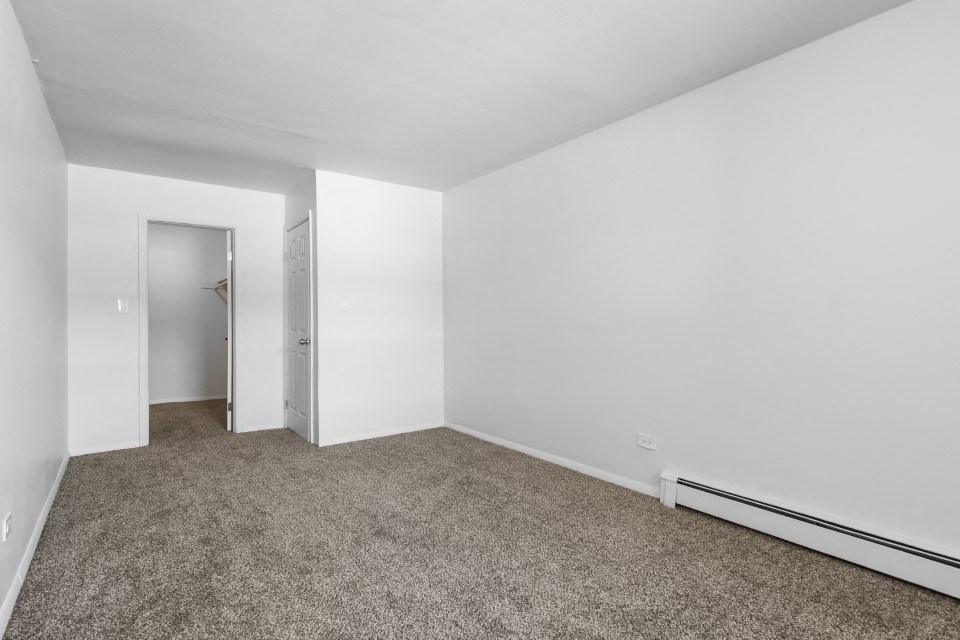 an empty room with carpet and a closet