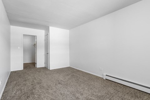 an empty room with carpet and a closet