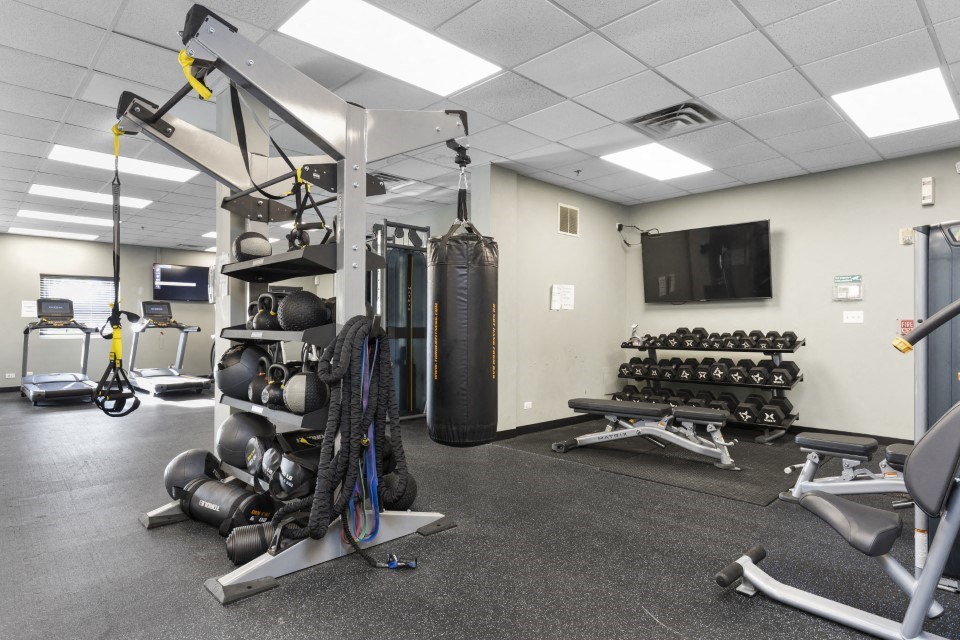 a gym with weights and other equipment in a building with a tv