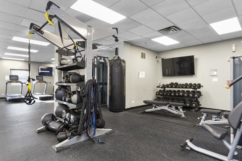 a gym with weights and other equipment in a building with a tv