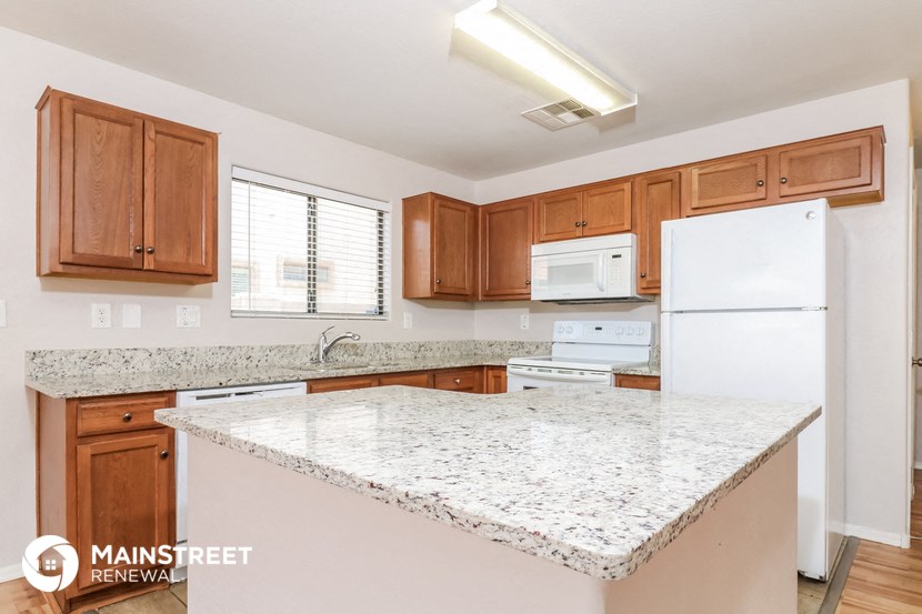 a kitchen with granite counter tops and wooden cabinets