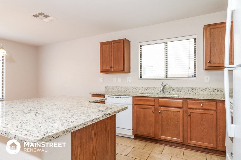 a kitchen with granite counter tops and wooden cabinets and a window