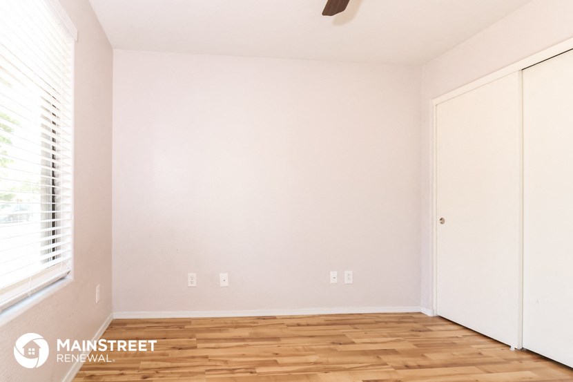 the upstairs bedroom with wood floors and white walls