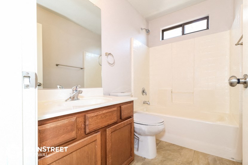 a bathroom with a toilet sink and shower and a mirror