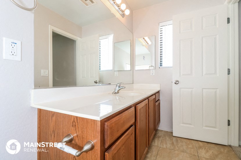 the master bathroom has a large vanity with a sink and a mirror