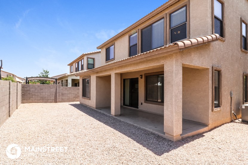 a side view of a house with a gravel driveway