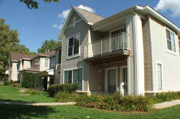 a row of houses with a porch and a yard