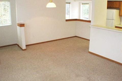 an empty living room with a white wall and carpet