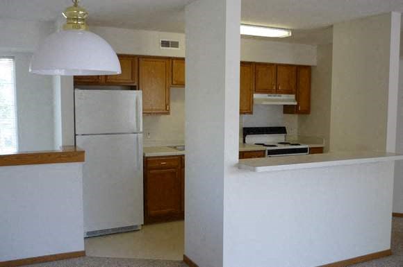 an empty kitchen with a refrigerator and a stove