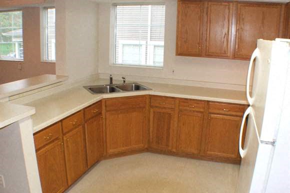 a kitchen with wooden cabinets and a sink and a refrigerator