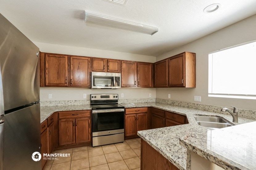 a kitchen with wooden cabinets and granite counter tops and stainless steel appliances