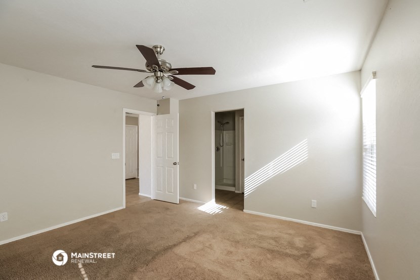 a living room with carpet and a ceiling fan