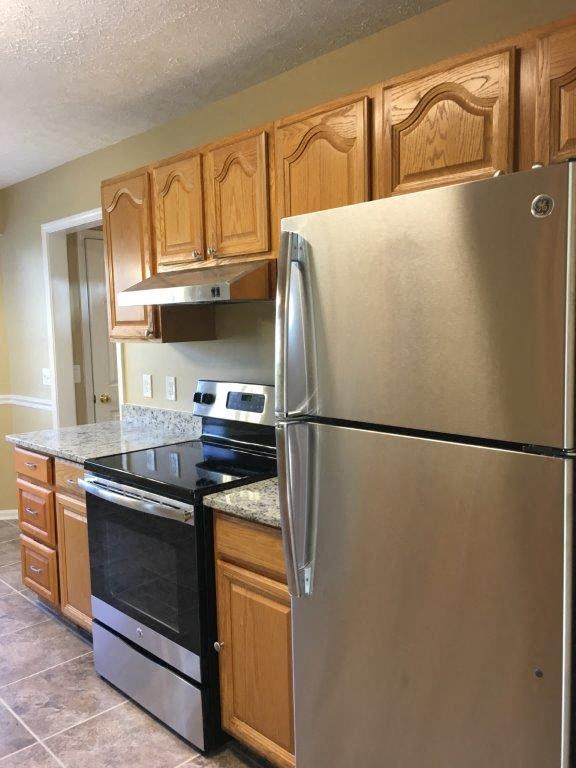 a kitchen with a stainless steel refrigerator and a stove