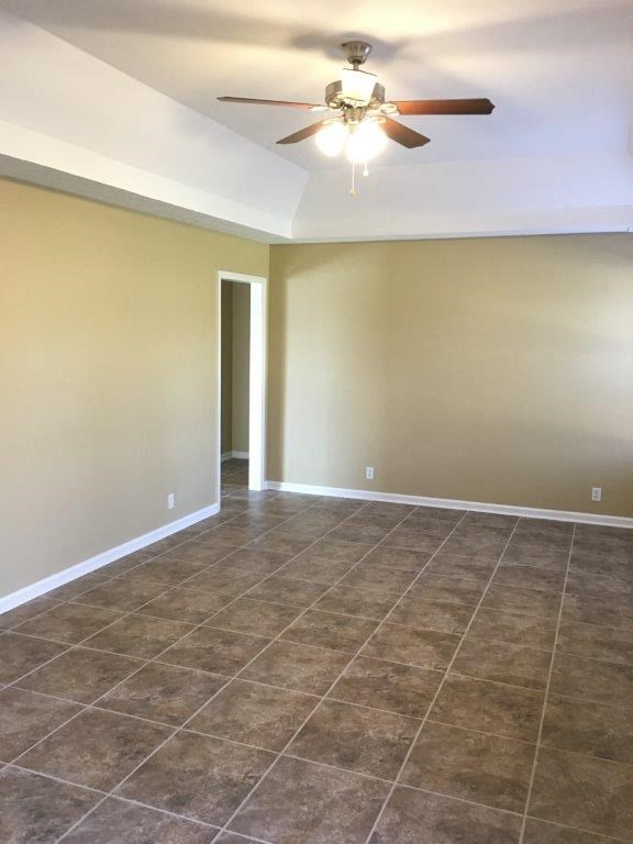 a empty living room with a ceiling fan