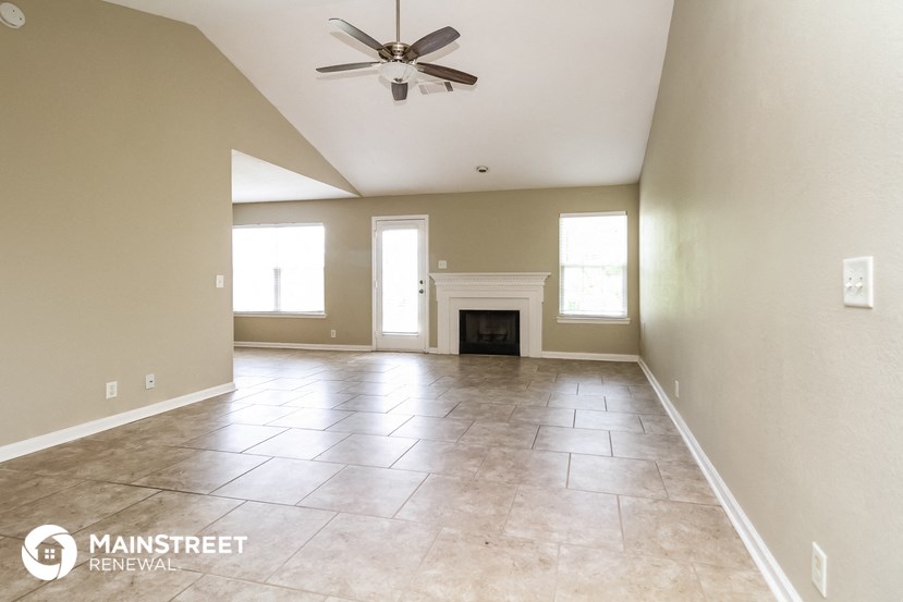the spacious living room with fireplace and tile flooring