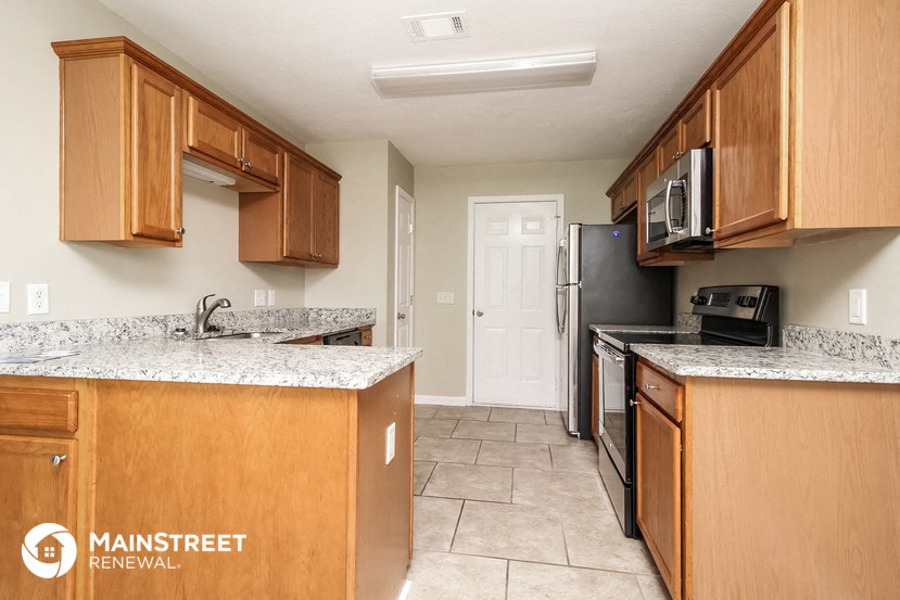 a kitchen with wooden cabinets and a black refrigerator