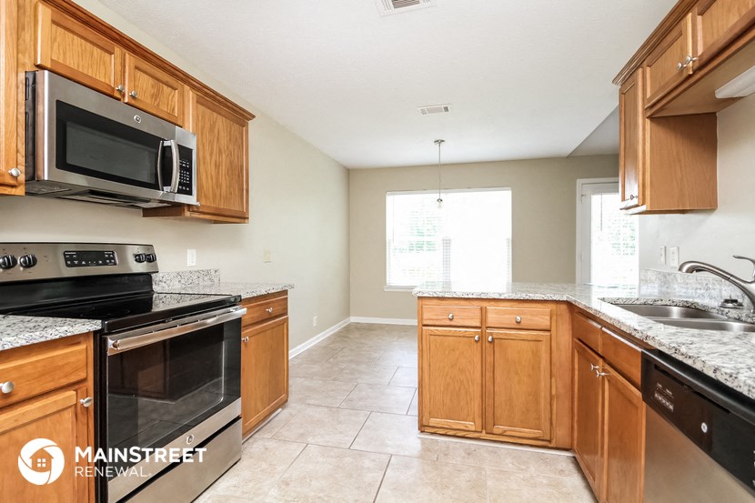a kitchen with wooden cabinets and a stove and a microwave