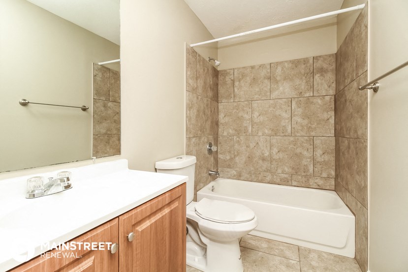a bathroom with a toilet and a tub and a sink