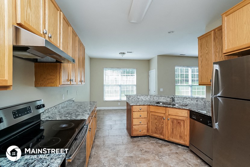 a kitchen with wooden cabinets and stainless steel appliances and granite counter tops