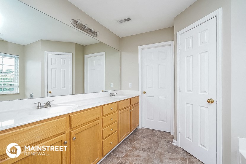 a bathroom with a sink and a mirror and two doors