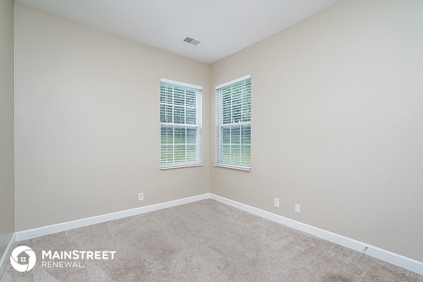 the master bedroom has a carpeted floor and two windows