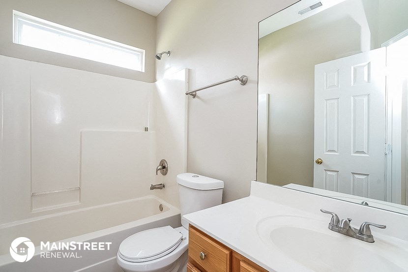 a bathroom with a sink toilet and tub and a mirror