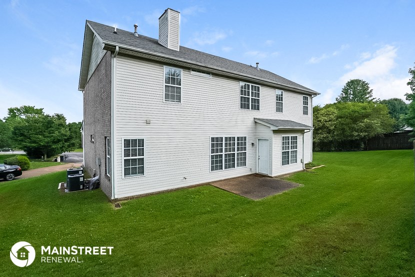 a white house with a lawn and a driveway