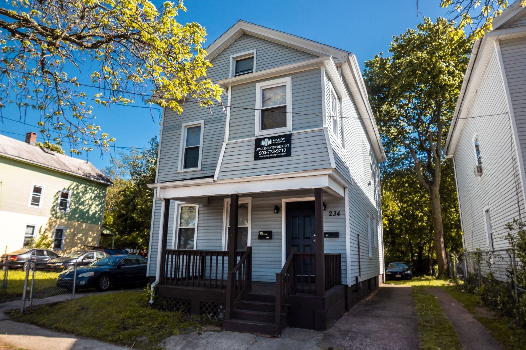 A two-story house with a porch and a garage door.