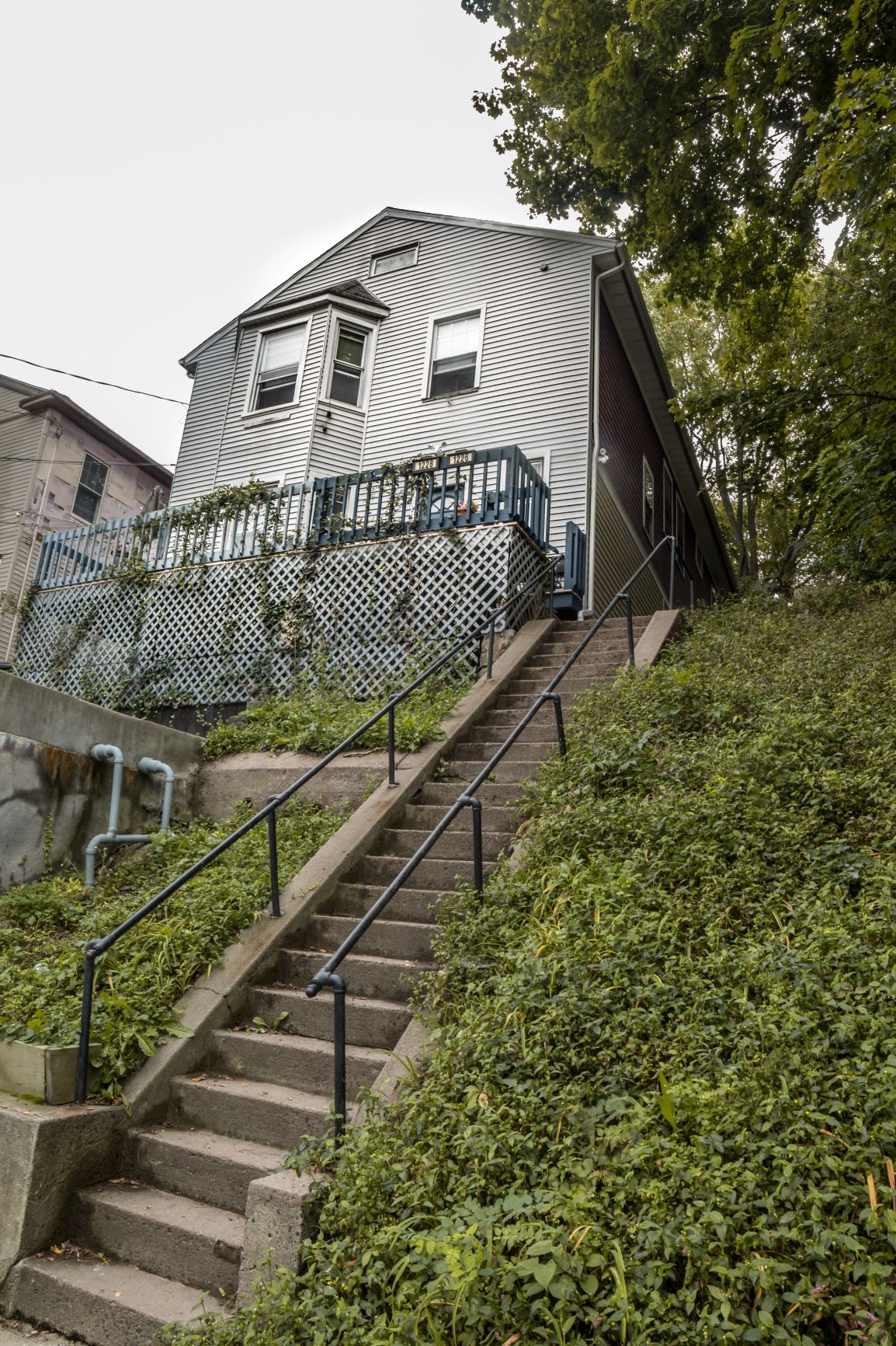 A staircase with a metal railing leads up to a house.