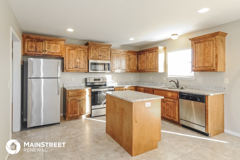 a kitchen with wooden cabinets and stainless steel appliances