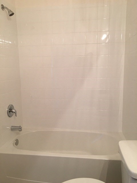 a white bathroom with a tub and a toilet