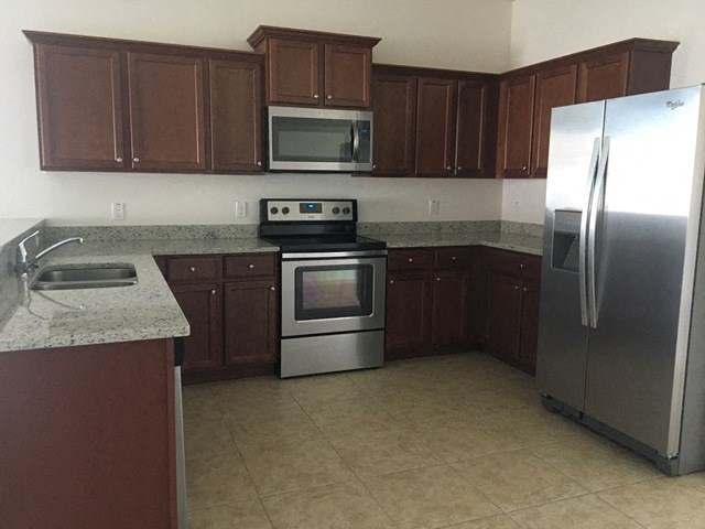 a kitchen with stainless steel appliances and brown cabinets