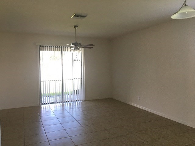 an empty living room with a ceiling fan