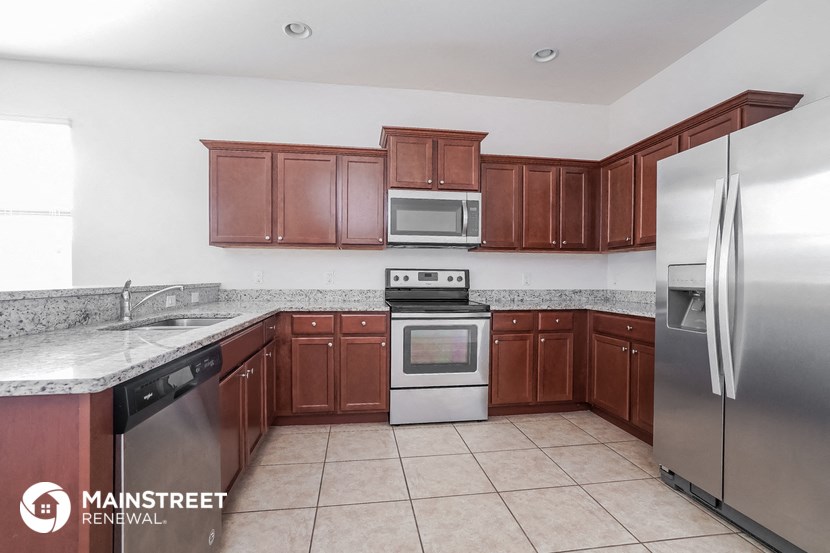 a kitchen with wooden cabinets and stainless steel appliances