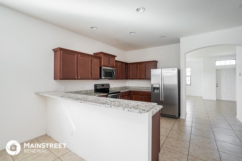 a large kitchen with granite countertops and stainless steel appliances