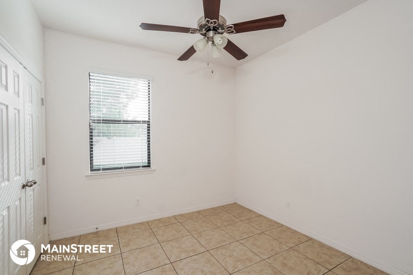 the living room of an empty house with a ceiling fan
